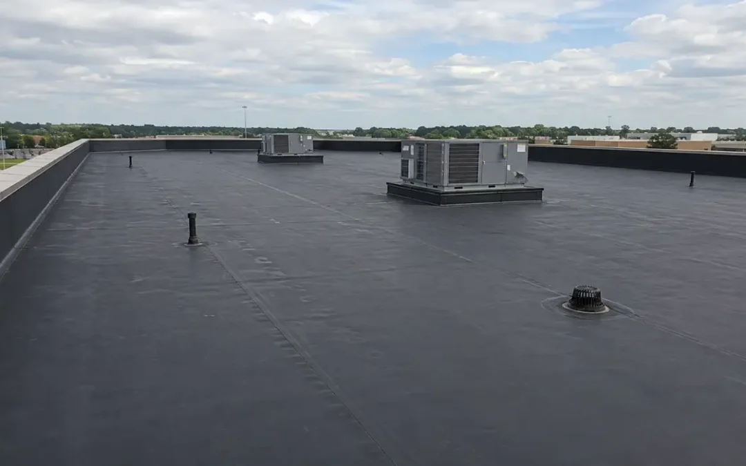 Commercial EPDM roofing showing membrane seams, roof drain, HVAC equipment, penetrations, perimeter flashing, and low-slope surface.